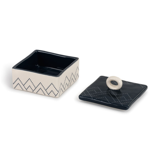 open ceramic box with black inside and lid and white outside, all with angular stitch designs
