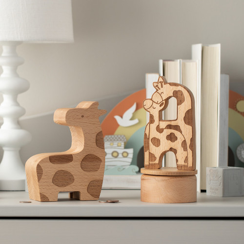 wooden giraffe bank and wooden giraffe and baby box sitting next to each other on dresser