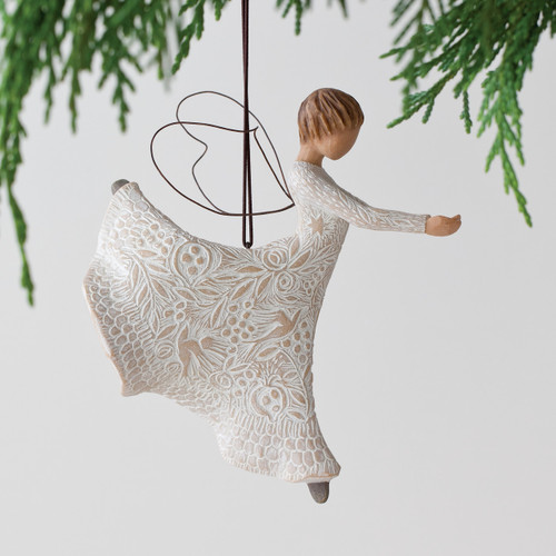 Faceless woman figurine hanging ornament wearing white dress with black wings - hanging from green branches