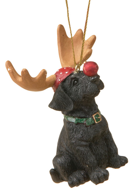 Black dog figurine ornament with brown reindeer horns balancing red ball on his nose and wearing a green collar