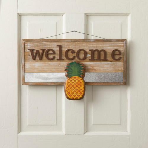 Wooden door banner with 'welcome' in brown above yellow pineapple - door is white wooden