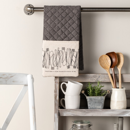 kitchen shelving with mugs, planter and white ceramic crock holding cooking utensils, towel with pocket hanging on rod