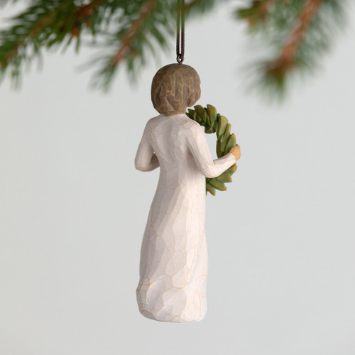 Back view, female figure in cream dress, holding green wreath of magnolia leaves. Hook and loop affixed to figure's head