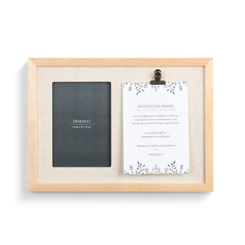 A simple light wood invitation frame with a gray product slip, a bronze clip, and a white product description page.