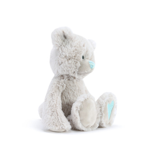 A side view of a fluffy white plush bear with a light blue nose and a light blue heart on the foot.