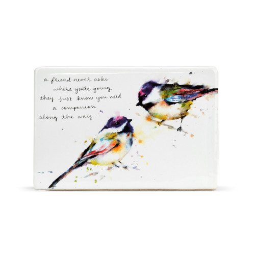 A white ceramic plaque with two watercolor painted birds and "a friend never asks where you're going. they just know you need a companion along the way" in black cursive font.