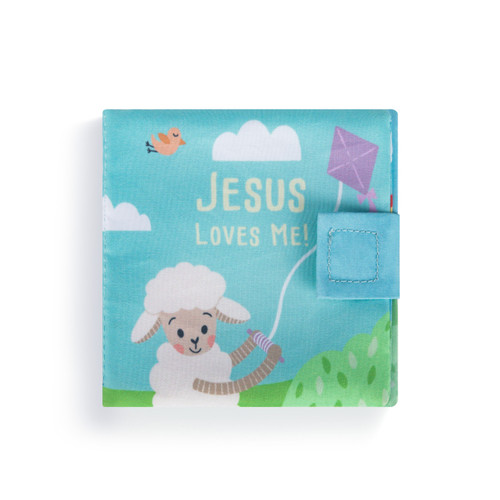 The cover of a soft activity puppet book. A small white lamb flying a purple kite in a field, and Jesus Loves Me" in yellow font."