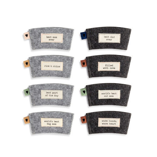 An assortment of four light gray and four dark gray coffee coozies, each with a different colored heart tab, and an ivory patch with a short sentimental message in black typewriter font.