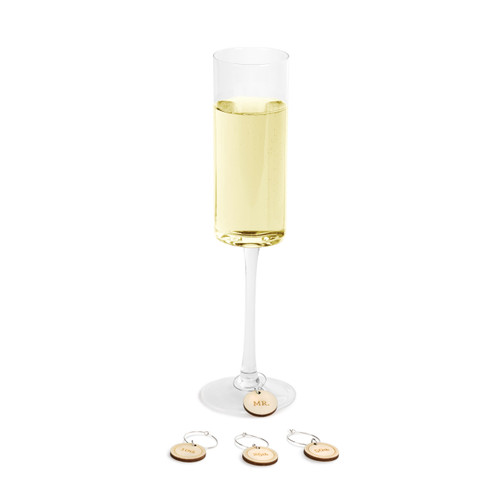 A thin glass filled with champagne and filled with small wooden glass rings.