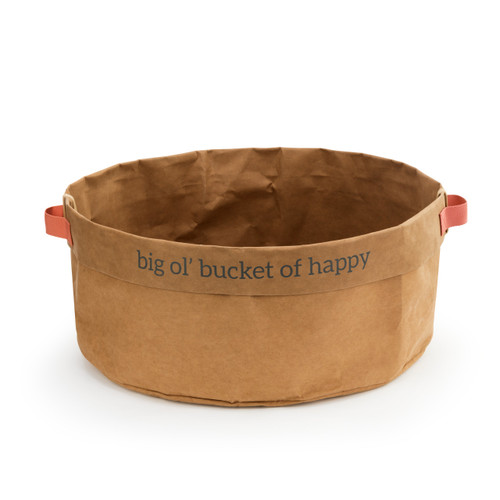 A large suede soft brown sack bowl, that reads big ol' bucket of happy" in black lettering. With two red handles, and a red tag."