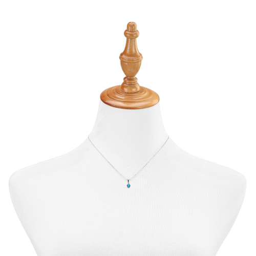 silver necklace with blue gem charm shown on mannequin