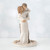 Woman and man figurine holding one another standing on round white plaque