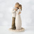 Faceless woman and man figurines standing on white plaque hugging one another