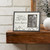 Wooden shelf with white/grey photo frame that says 'little memories last a lifetime' on it