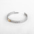 Silver bracelet band with 'giving soul' in black lettering next to gold butterfly, open clasp