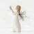Side view of young girl figurine in white dress with brown wire wings holding up butterfly figurine