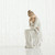 Faceless mother figurine sitting down holding baby - all wearing white and all white background