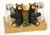 Two black bear figurines sitting in between wooden trunk beside salt and pepper shakers