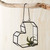 heart shaped hanging wire and glass container hanging on branch