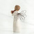 Back view of brunette angel figurine in white dress with wire wings holding red apples