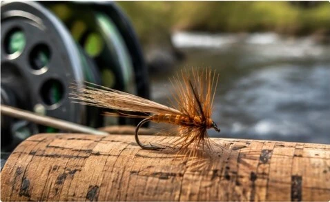 Finished fly resting on a cork fishing rod handle