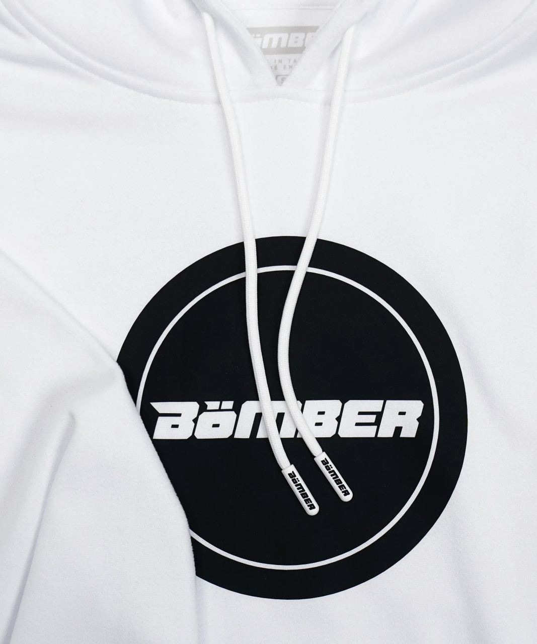 Close-up of Bomber logo on white performance hoodie