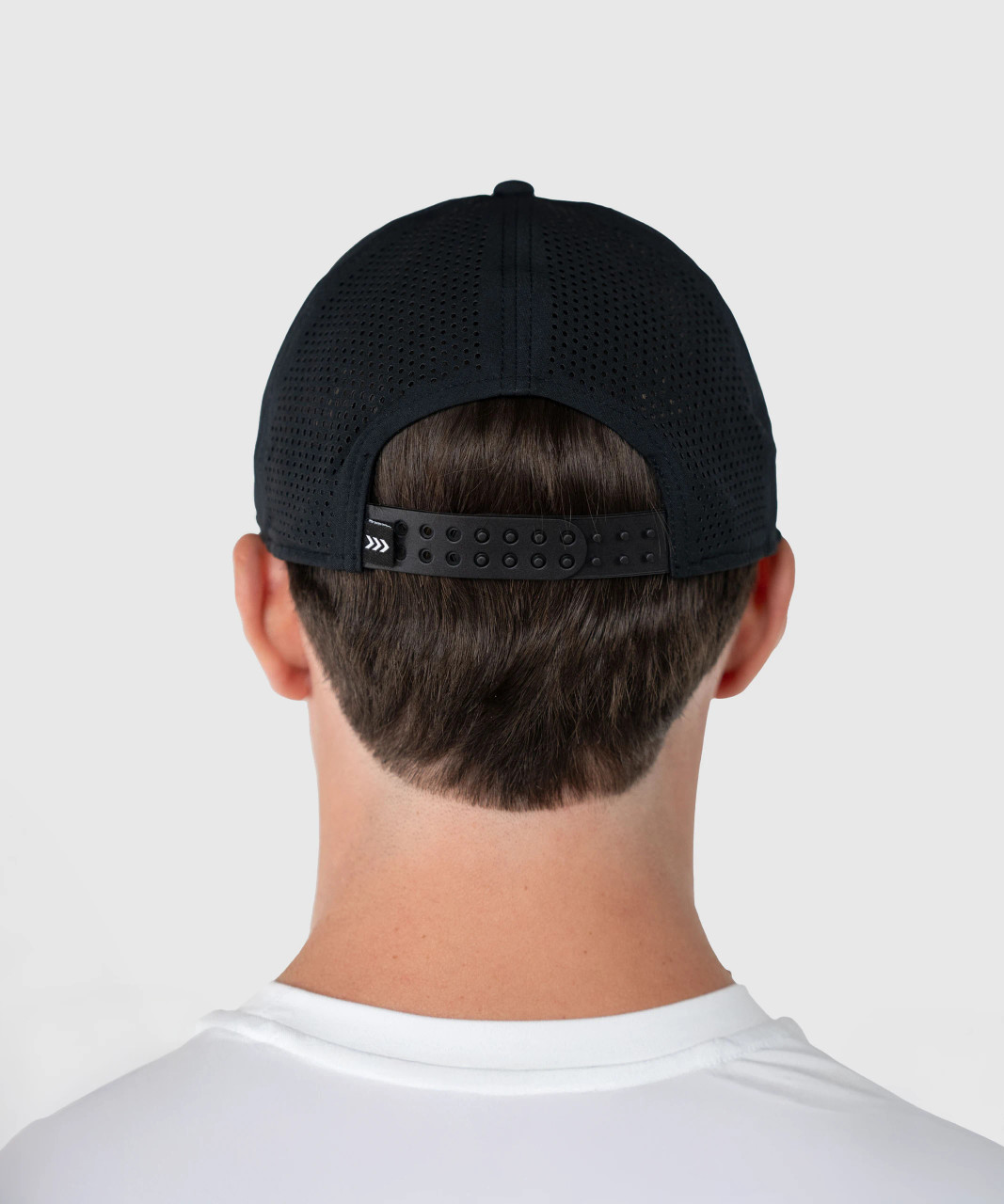 Back view of man wearing black snapback performance hat