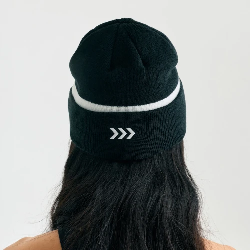 Charge Beanie, unisex black cuffed knit beanie, female model, back view
