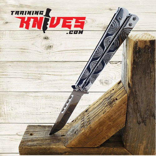 Hero – Chrome 440 Steel Balisong Butterfly Trainer fully open with unsharpened blade, leaning against a tree stump, showcasing polished chrome skeletonized handles Hero – Chrome 440 Steel Balisong Butterfly Trainer fully open with unsharpened blade, leaning against a tree stump, showcasing polished chrome skeletonized handles