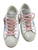 Golden Goose low-top sneakers with white leather panels, gray suede toe boxes, pink laces, contrasting star details, and a distressed finish. View 1