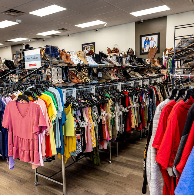 A clothing rack full of nice clothes and shoes