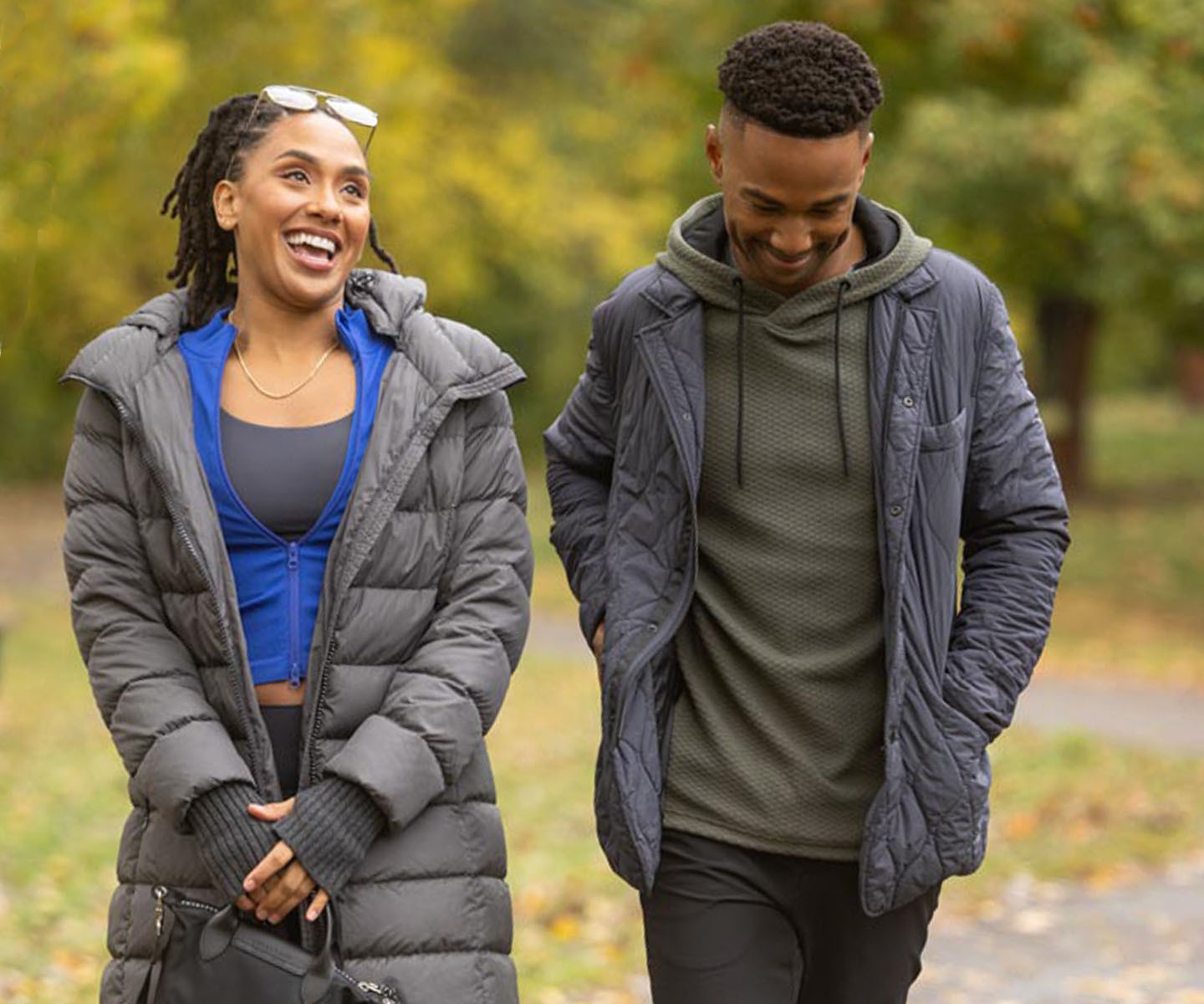 man and woman walking outside wearing coats