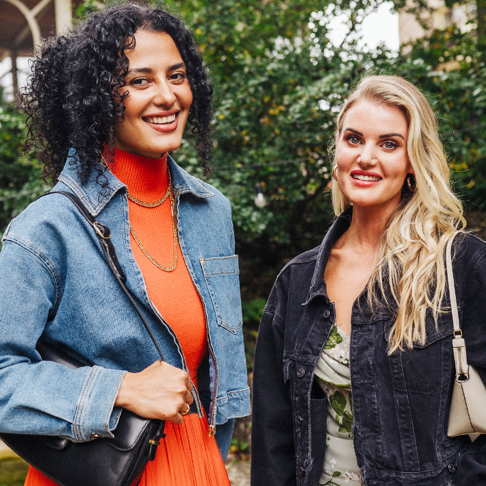 two women standing together smiling at camera