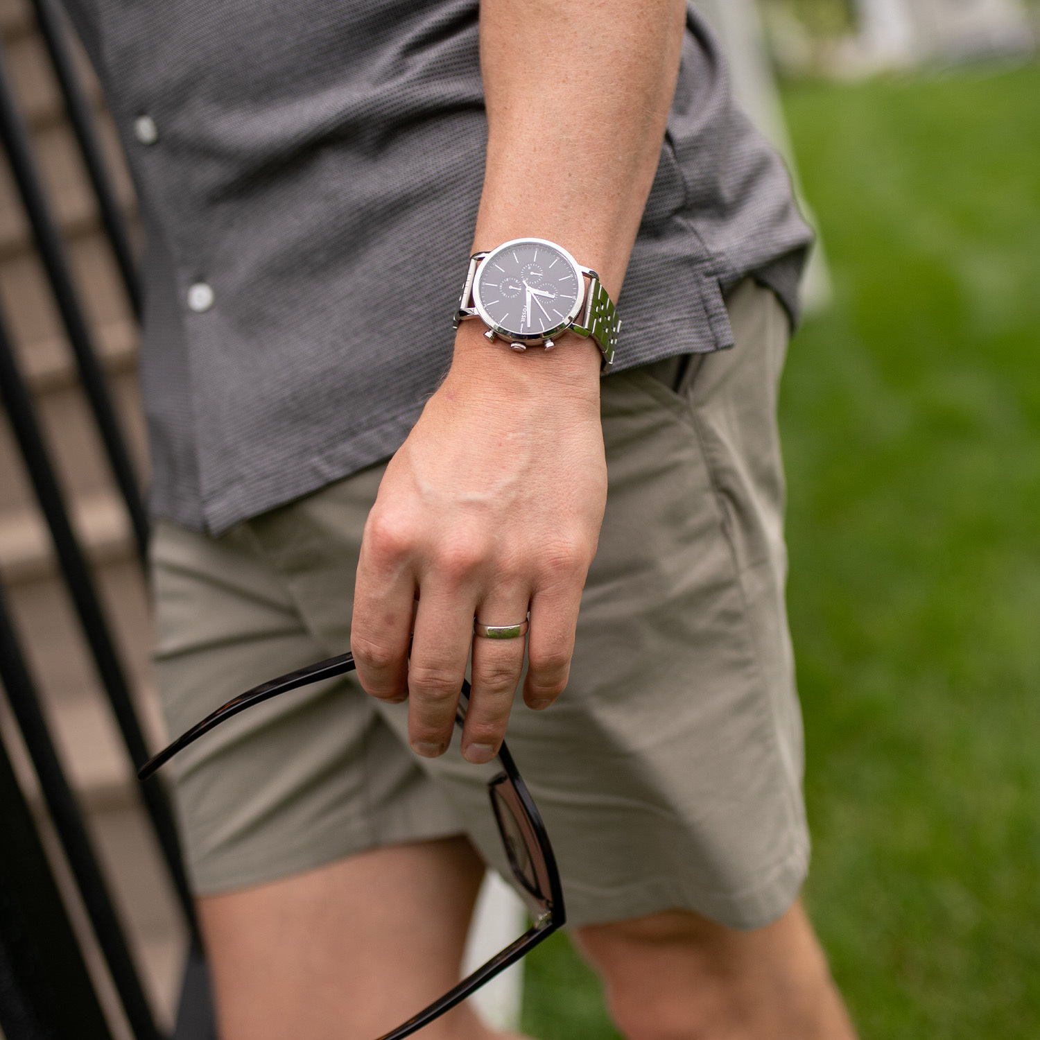 Man wearing short sleeve top, shorts and watch.