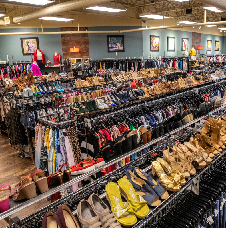 A clothing rack full of nice clothes and shoes