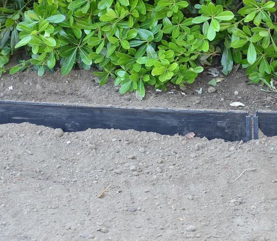 Root barrier panel placed along planting bed to protect adjacent hardscape