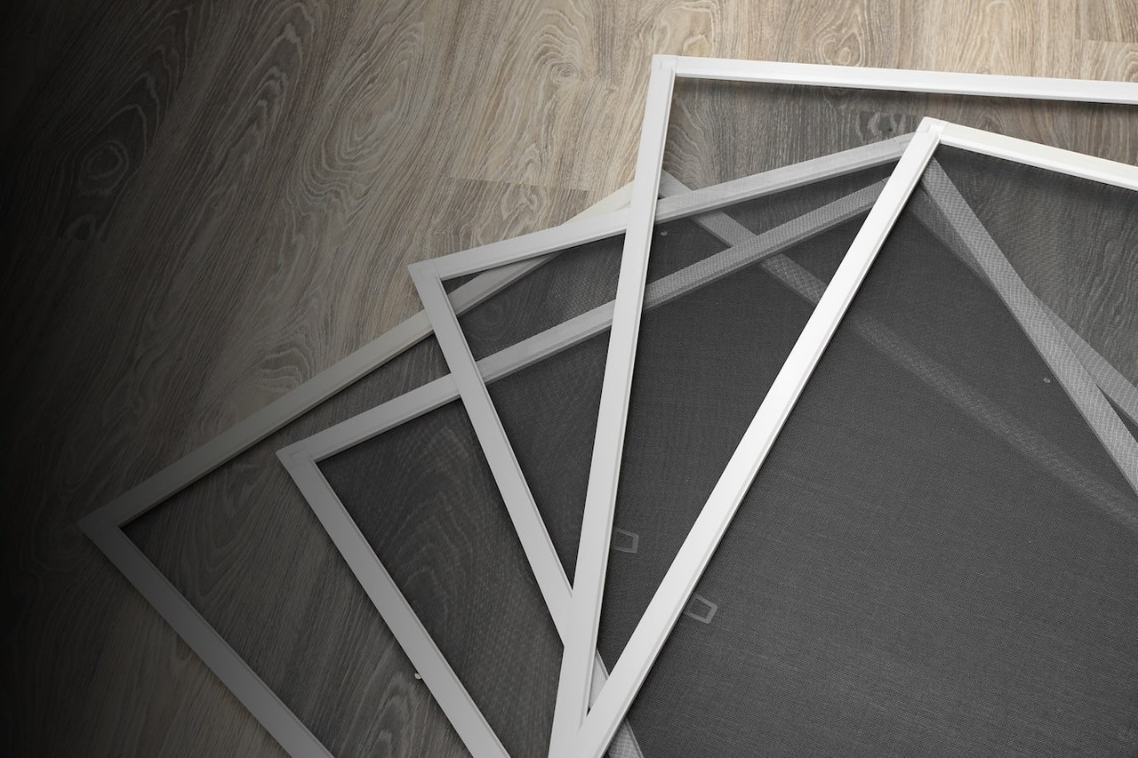 Image of window screens with white rims in a pile