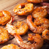 Grilled wild-caught Biloxi Gulf shrimp on a wooden table.