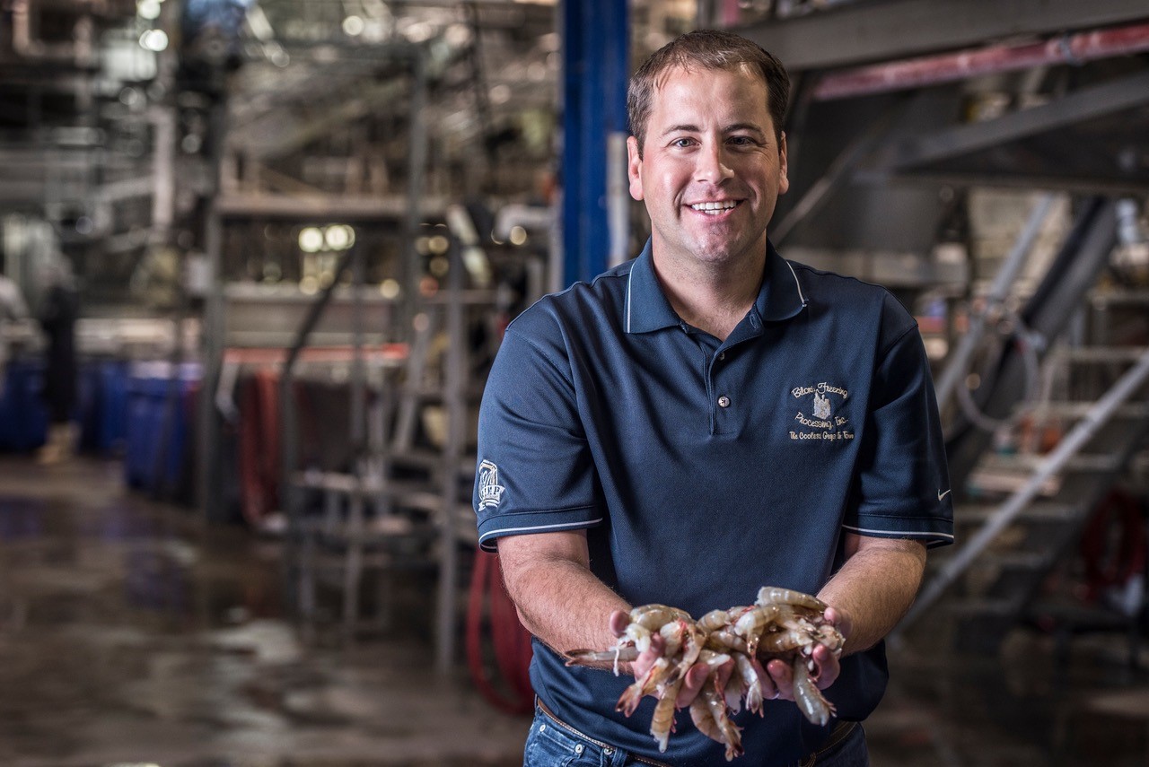 Jonathan McLendon holding shrimp at Biloxi Freezing Plant