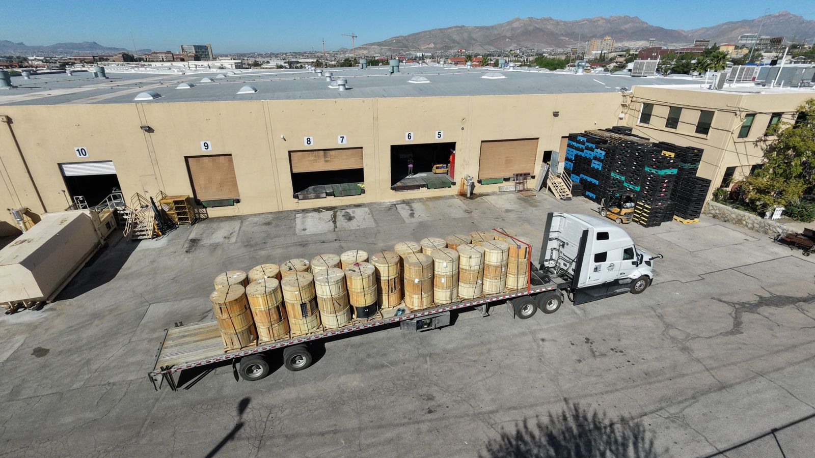 Aerial view of OCO Industrial loading docks in El Paso with a flatbed of cable reels being transloaded