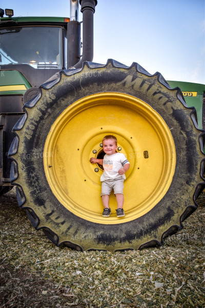 Toddler in Wheel of Tractor 56522