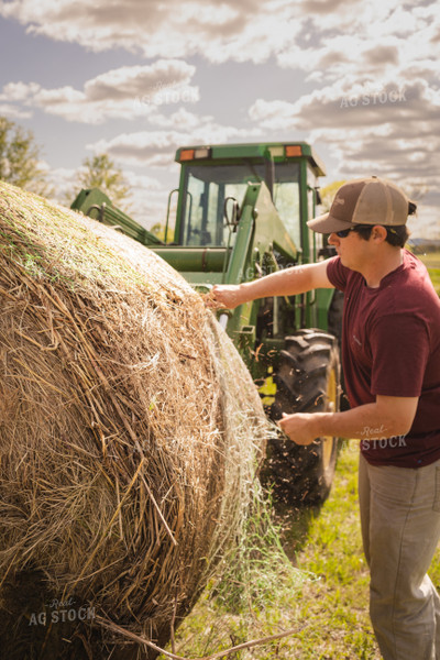 Farmer Unwrapping Hay Bales 128016