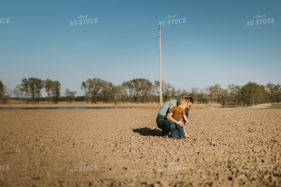 Farm Wife and Child Check Seed Depth During Planting 7640