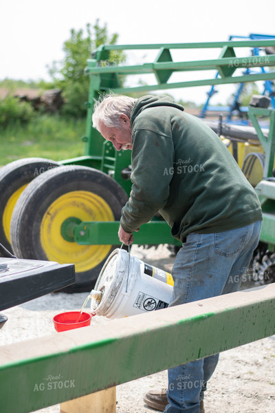 Farmer Pours Hydraulic Oil into Funnel 50368