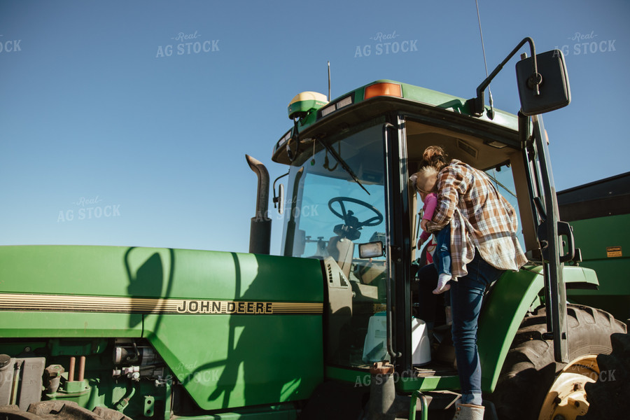 Female Farmer Loading Kids into Tractor 67541