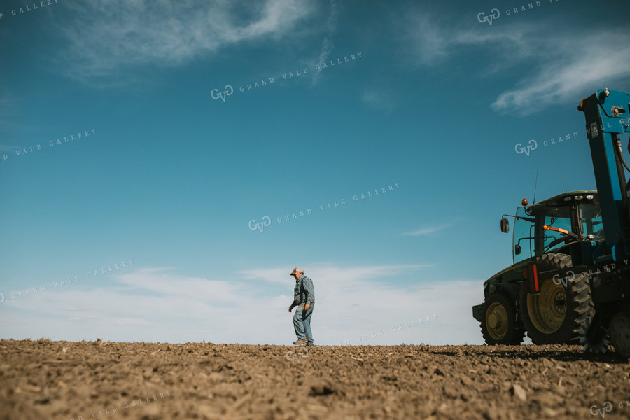 Farmer Climbing out of Tractor with Planter 4098