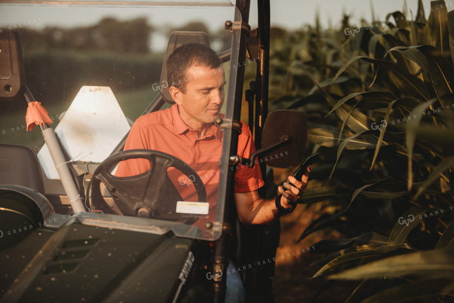 Farmer Checking Corn Crop in UTV with Smart Phone 4558