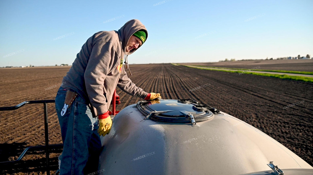 Farmer Loading the Planter with the Seed Tender 25202