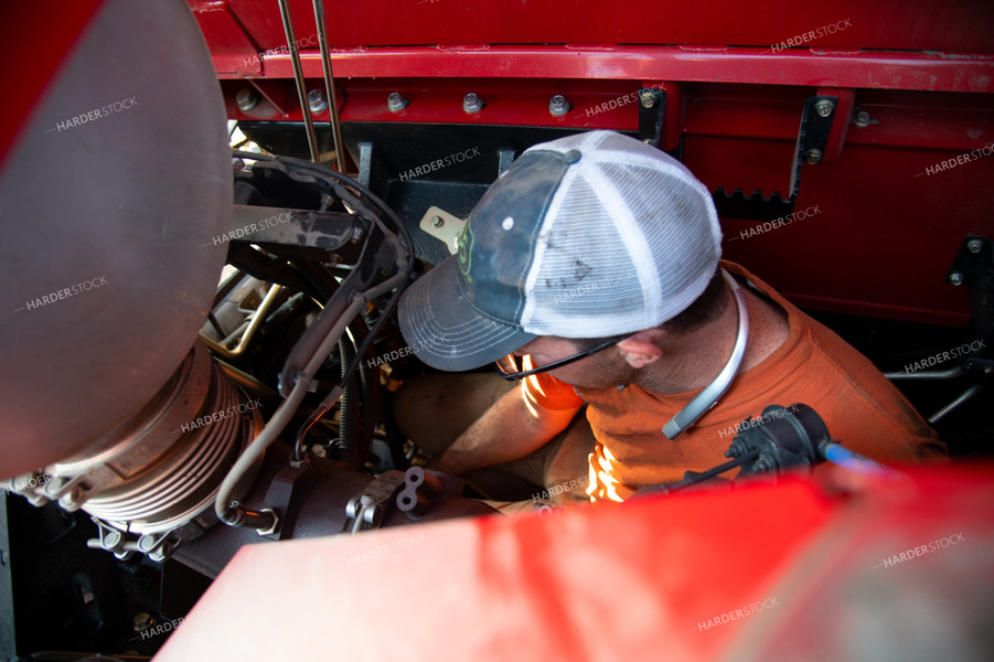 Farmer Repairing Combine 25443