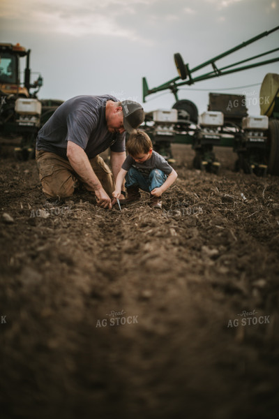 Farmer and Farm Kid Checking Seed Depth 5656